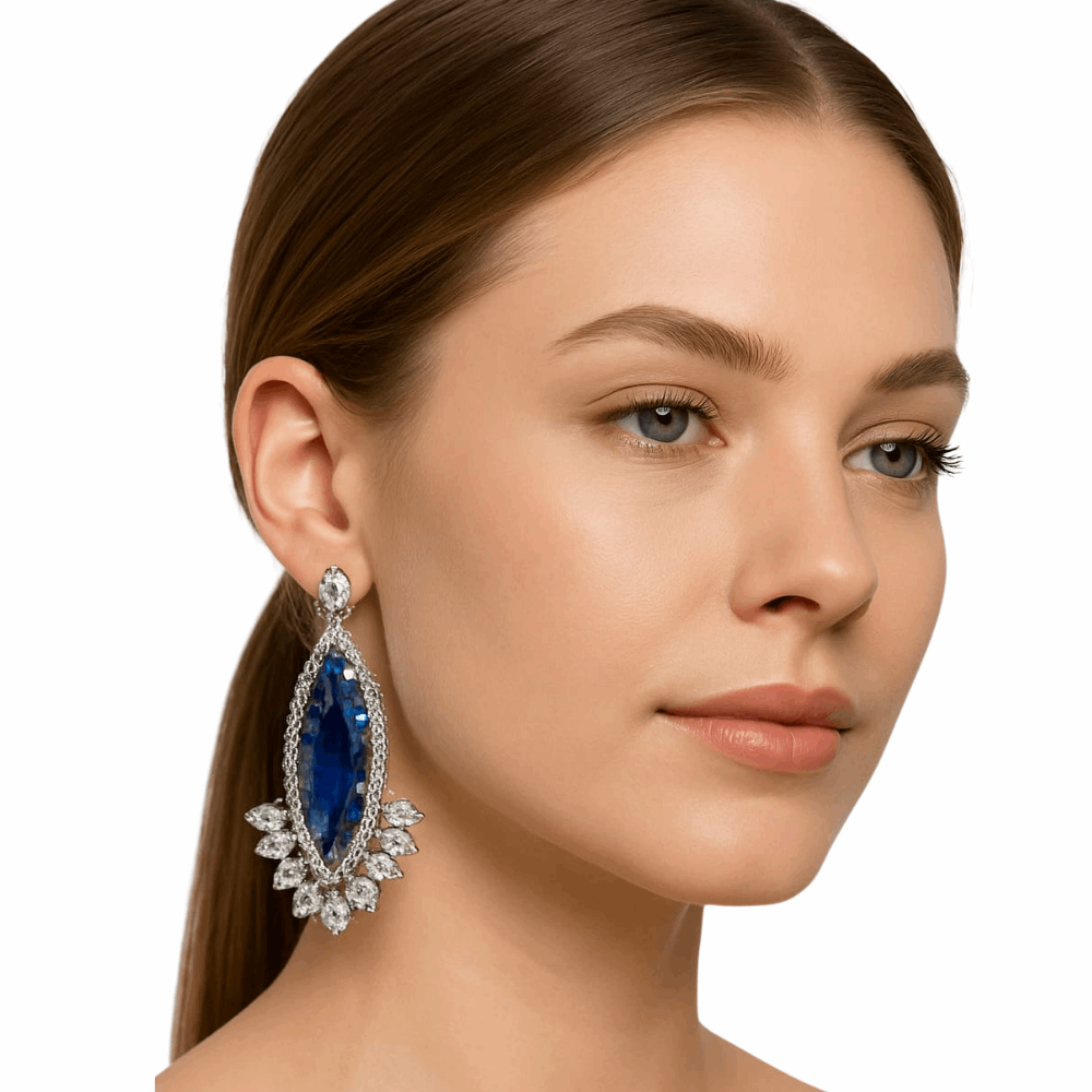 Woman wearing a blue teardrop earring with a white background