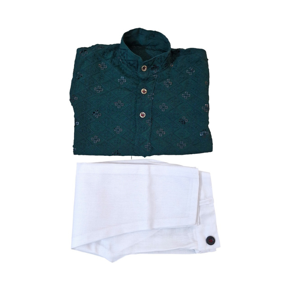 Folded green shirt with floral pattern and white pants on a white background