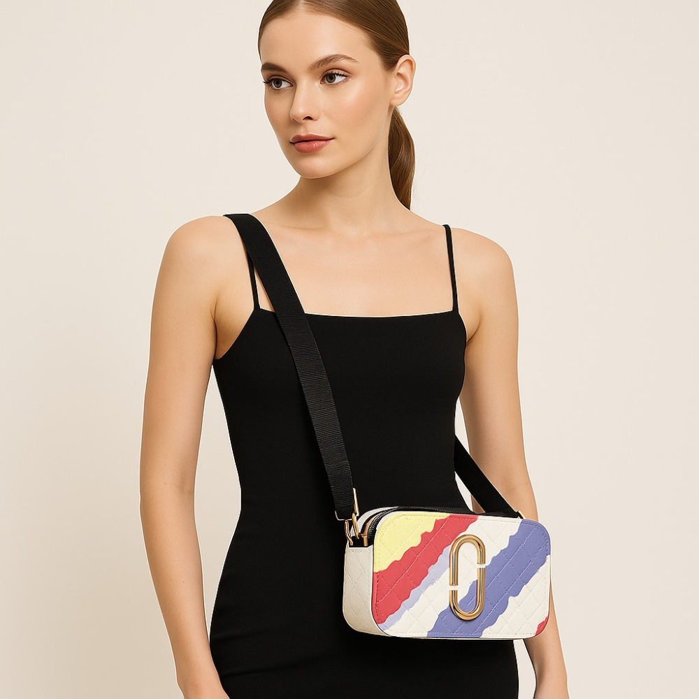 Model carrying a colorful handbag with a visible brand logo against a neutral background