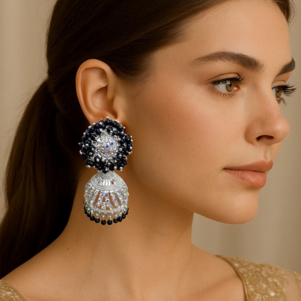 Woman wearing a pair of ornate earrings with a neutral background