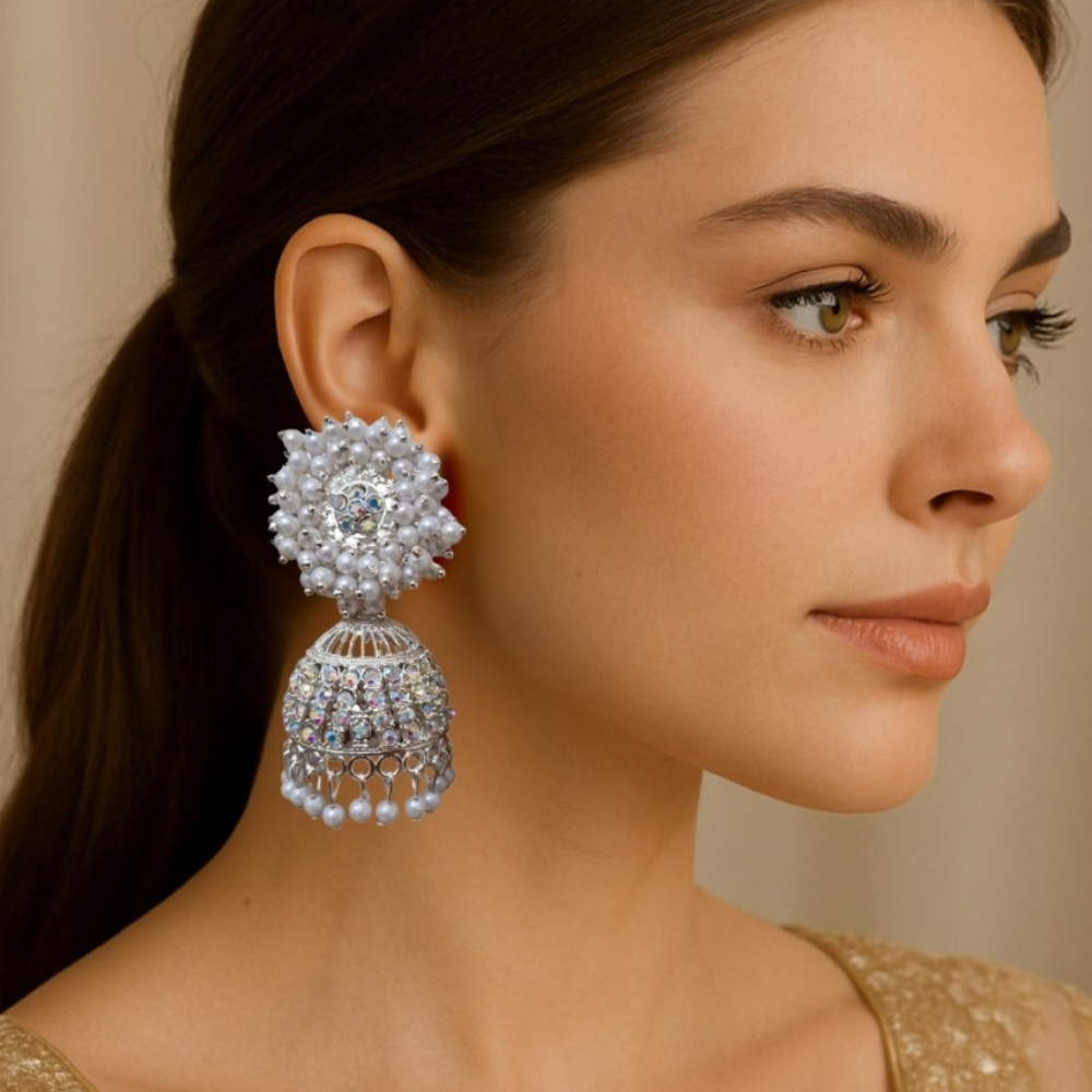 Woman wearing a large, ornate earring with a neutral background