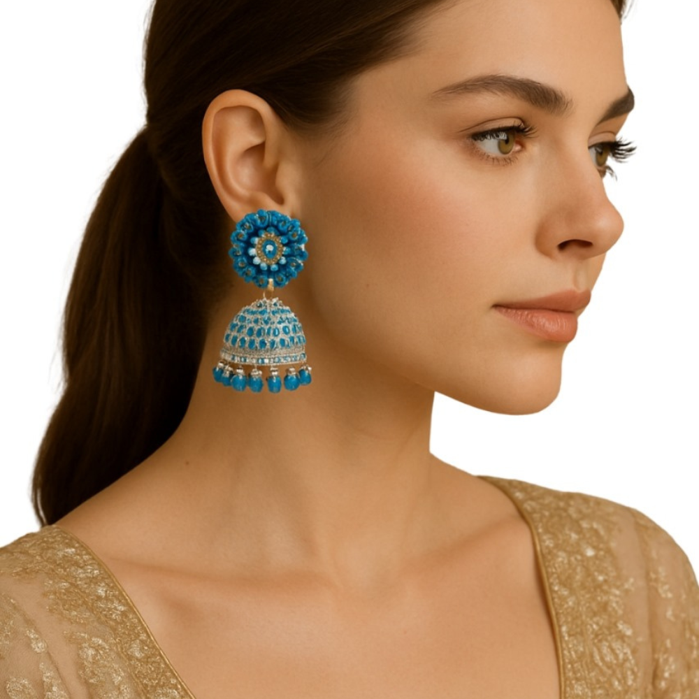 Woman wearing blue beaded earrings with a plain background