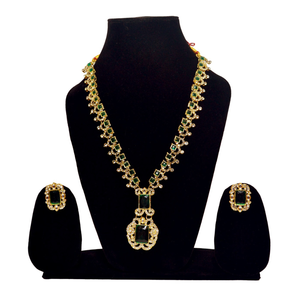 Gold and green necklace set on a black mannequin with earrings displayed.