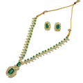 Gold necklace with green gemstones and matching earrings on a white background
