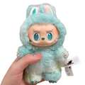 Plush toy with a hood held by a hand, brand tag visible